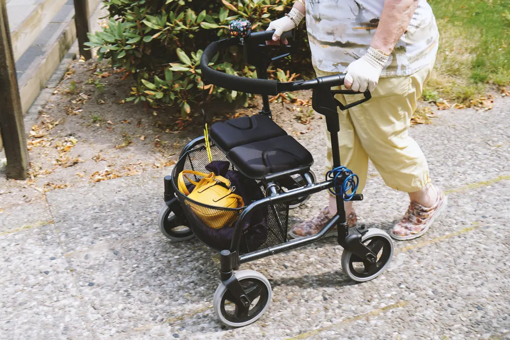 Close view of a rollator being pushed outdoors